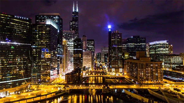 an image of the Chicago skyline with skyscrapers, with traffic, a train, and boats moving across it at different angles